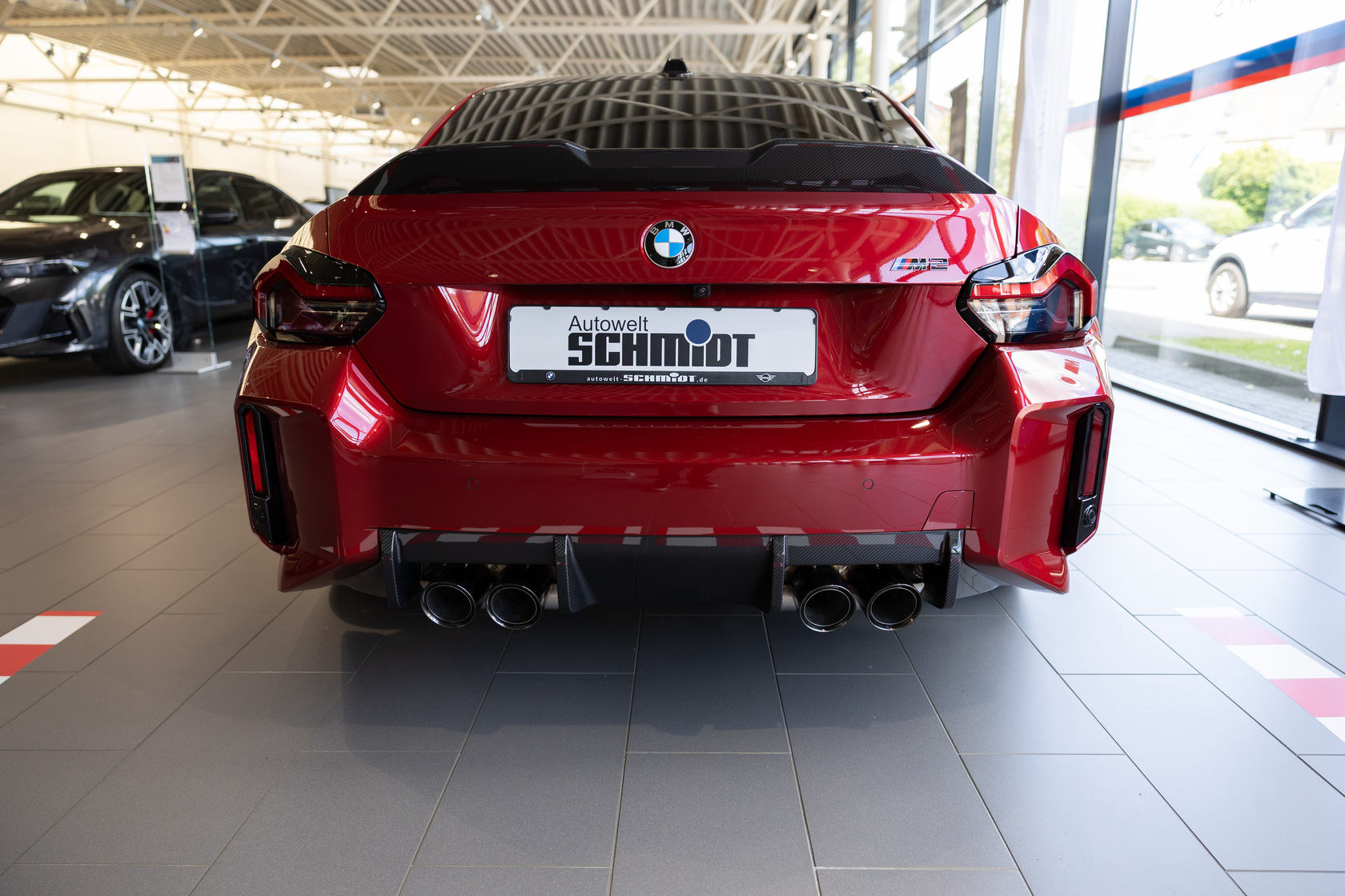 Heckansicht eines roten BMW M2 Coupé in einer Verkaufshalle