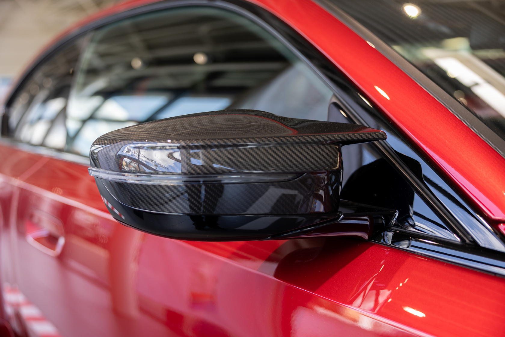 Seitliche Außenspiegel von einem roten BMW M2 Coupé mit Umbau mit M Performance Parts