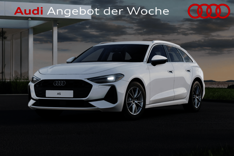 Weißer Audi A5 Avant in moderner Umgebung vor einem Haus mit großem Schriftzug „Audi Angebot der Woche“ und vier Audi-Ringen oben rechts.