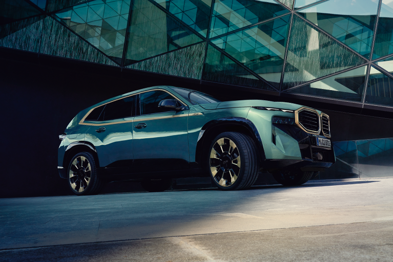 BMW XM vor einer Glas Fassade.