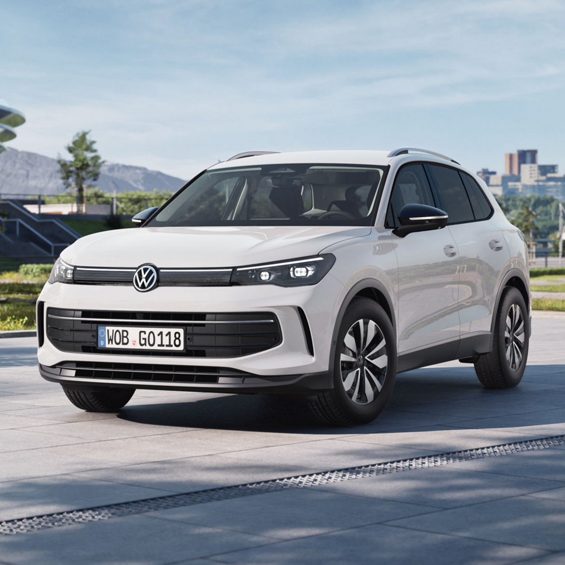 Weißer Volkswagen Tiguan in Frontansicht geparkt auf einem modernen Stadtplatz 