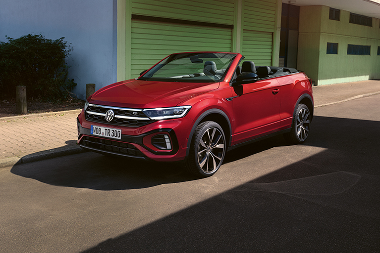VW T-Roc Cabriolet geparkt an in einer Straße vor grünen Garagen.