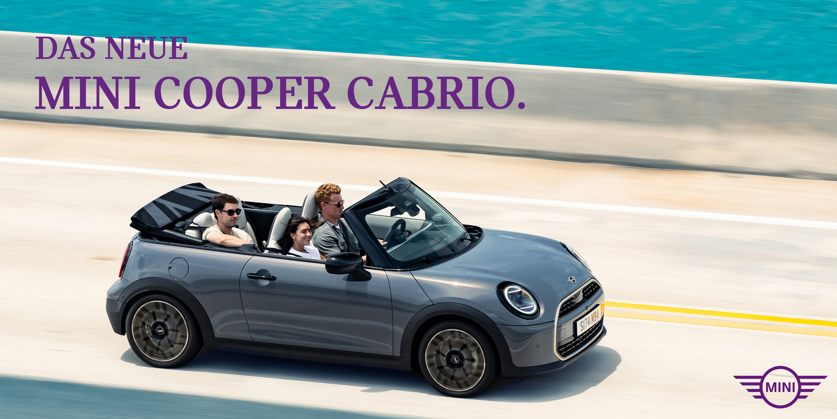 Graues MINI Cooper Cabrio mit offenem Verdeck, fahrend auf einer Straße neben dem Meer. Im Fahrzeug sitzen drei Personen. Oben links im Bild der Schriftzug: "Das Neue MINI Cooper Cabrio". Unten rechts das MINI Logo.