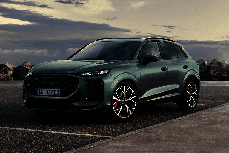 Grüner Audi Q3 SUV auf einem Parkplatz mit Meer im Hintergrund