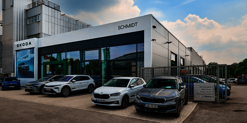 ußenansicht des ŠKODA Autohauses Schmidt in Lünen mit mehreren geparkten ŠKODA Fahrzeugen vor dem Gebäude und sichtbarem Eingang zum Haus.