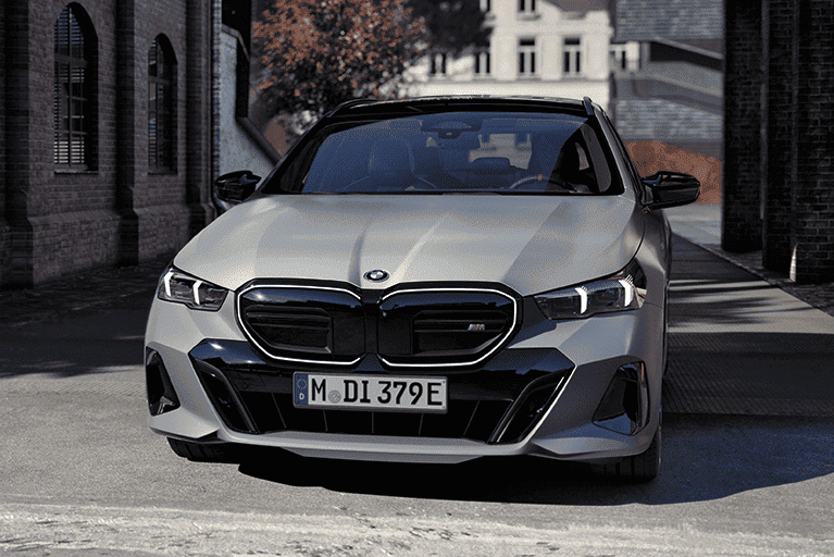 Grauer BMW i5 in Frontansicht in städtischer Umgebung