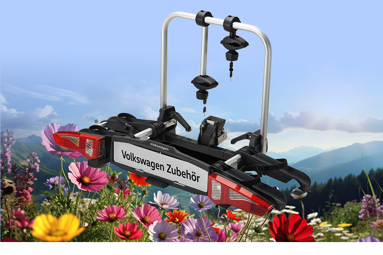 Fahrradträger von Volkswagen Zubehör vor alpiner Berglandschaft mit bunten Frühlingsblumen – ideal für den Transport von Fahrrädern am Auto
