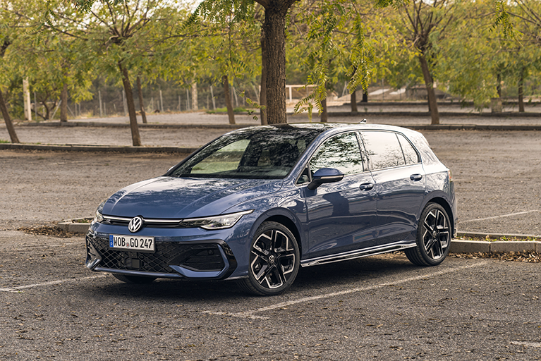 Blauer VW Golf R-Line parkt auf einem Platz mit Bäumen im Hintergrund. Sportlicher Kompaktwagen mit dynamischem Exterieur.