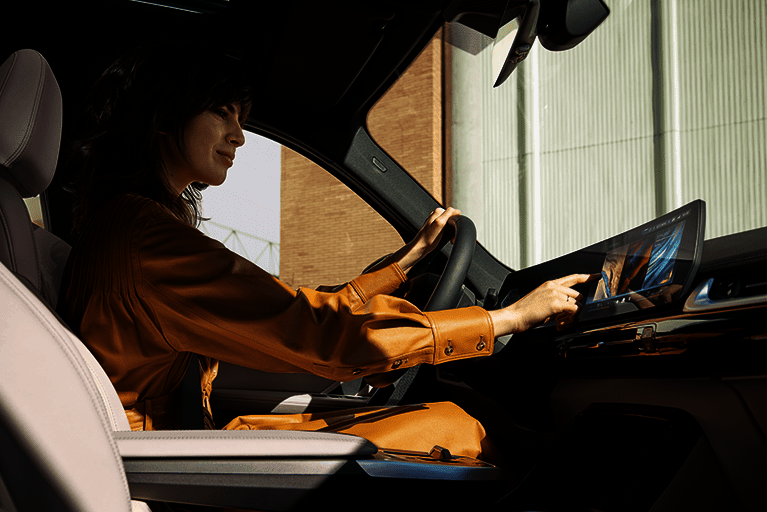 Fahrerin bedient das Infotainmentsystem des BMW 1er mit intuitivem Touchscreen und smarten Assistenzfunktionen