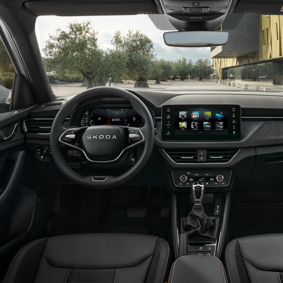 Modernes Škoda-Interieur mit großem Touchscreen und Multifunktionslenkrad in dunklem Design.