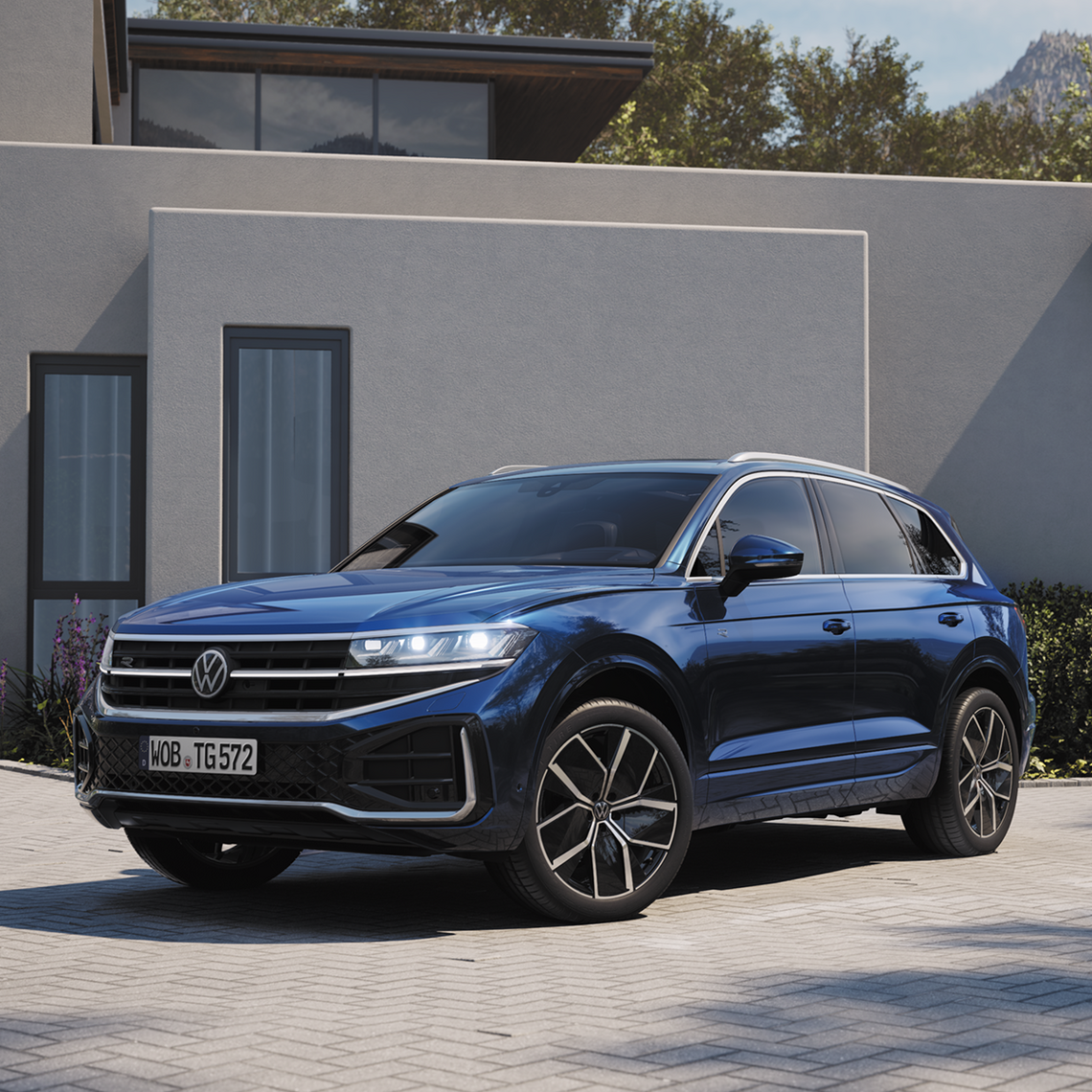 Blauer Volkswagen Touareg in seitlicher Frontansicht, geparkt vor moderner Hausfassade mit großen Fenstern.