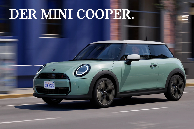 MINI Cooper in Mintgrün fährt auf einer städtischen Straße vor unscharfem Hintergrund; über dem Auto der weiße Schriftzug "DER MINI COOPER."