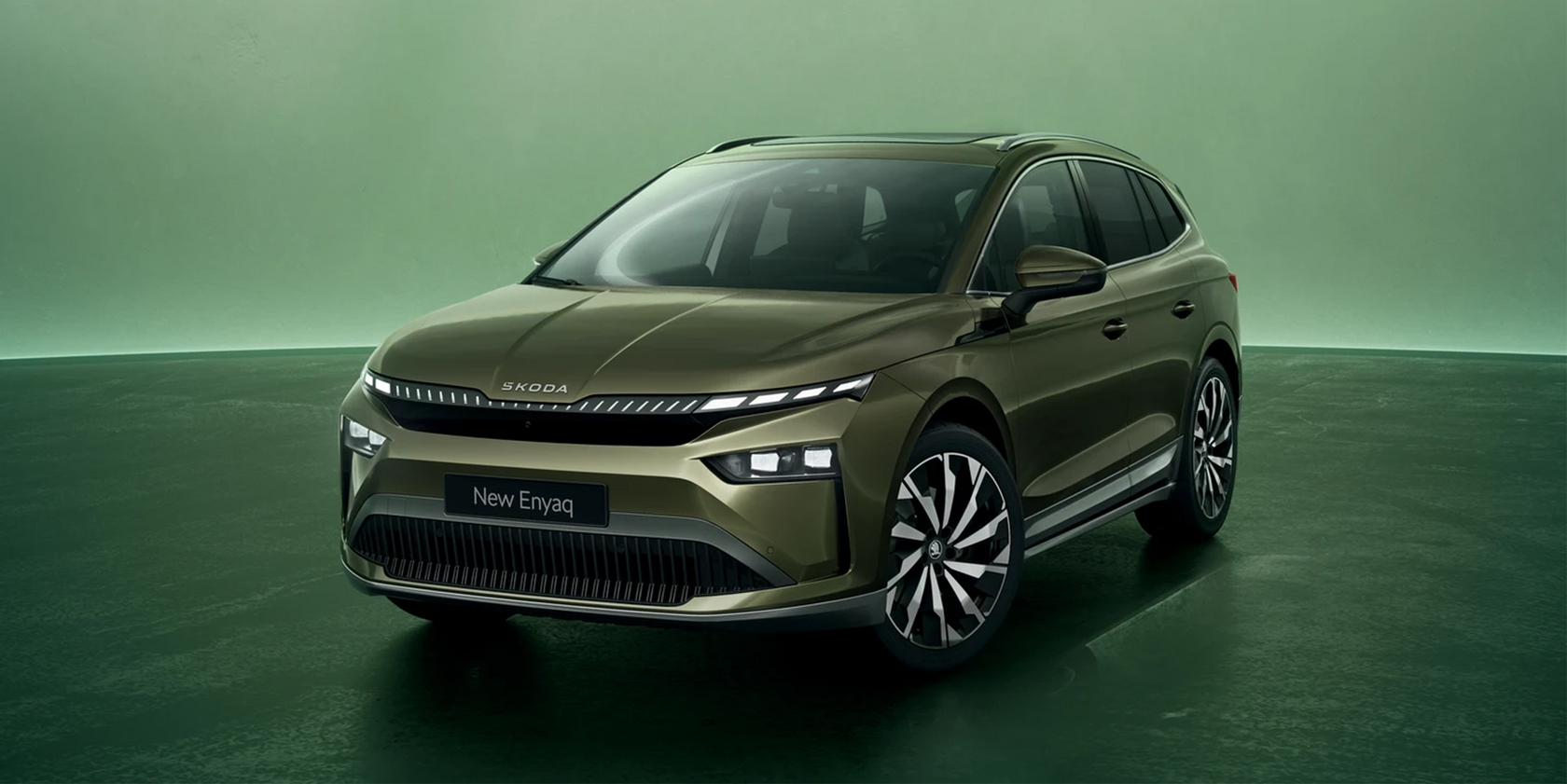 Dunkelgrüner Skoda Enyaq in Seiten- und Frontansicht vor einem grünen Hintergrund
