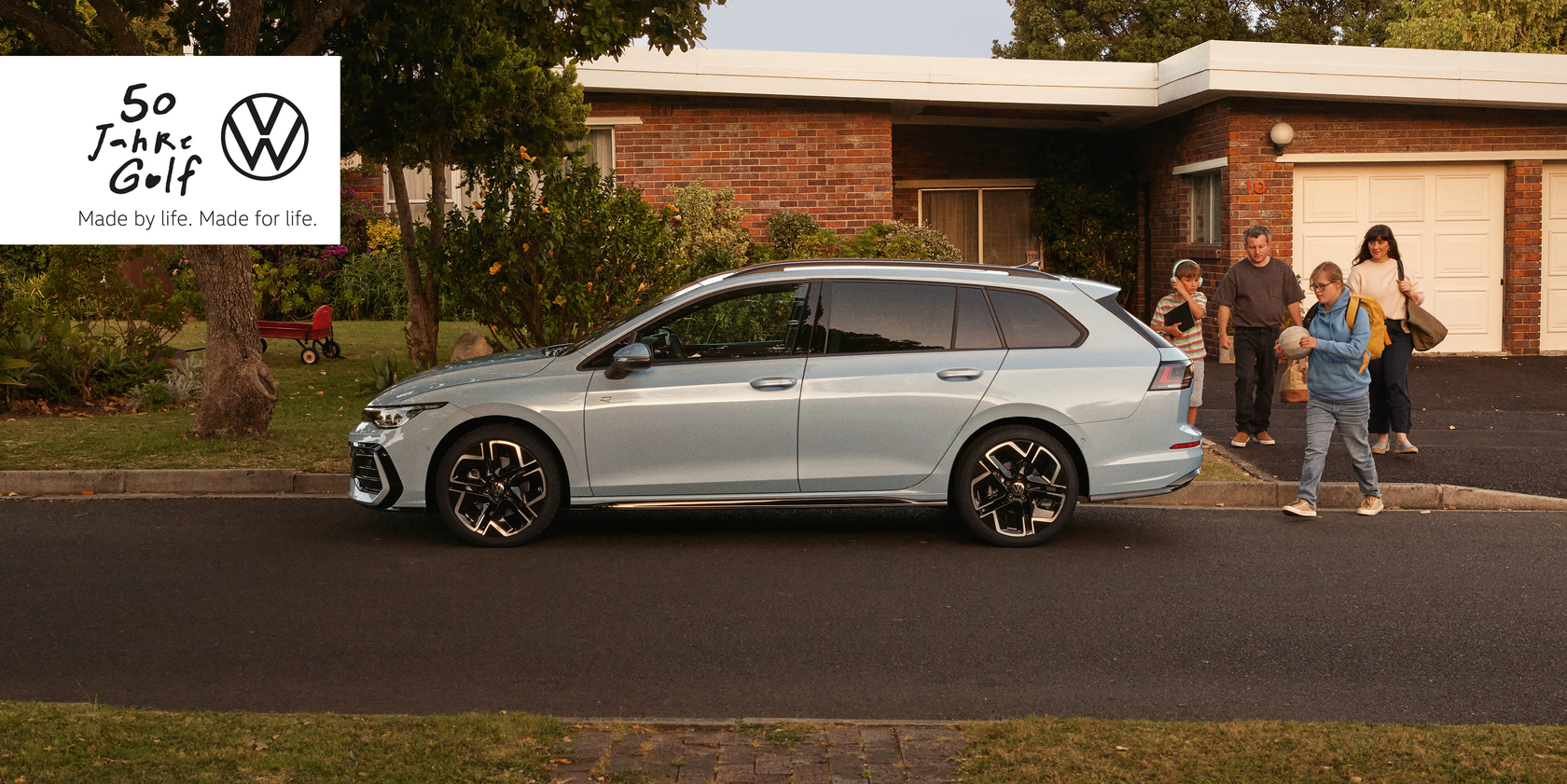Hellblauer VW Golf Variant R-Line (2024 Facelift) in Seitenansicht, geparkt vor einem Wohnhaus, vierköpfige Familie geht auf das Auto zu. Oben links im Bild weißer Kasten mit dem Schriftzug: "50 Jahre Golf – Made by life. Made for life." und das VW Logo