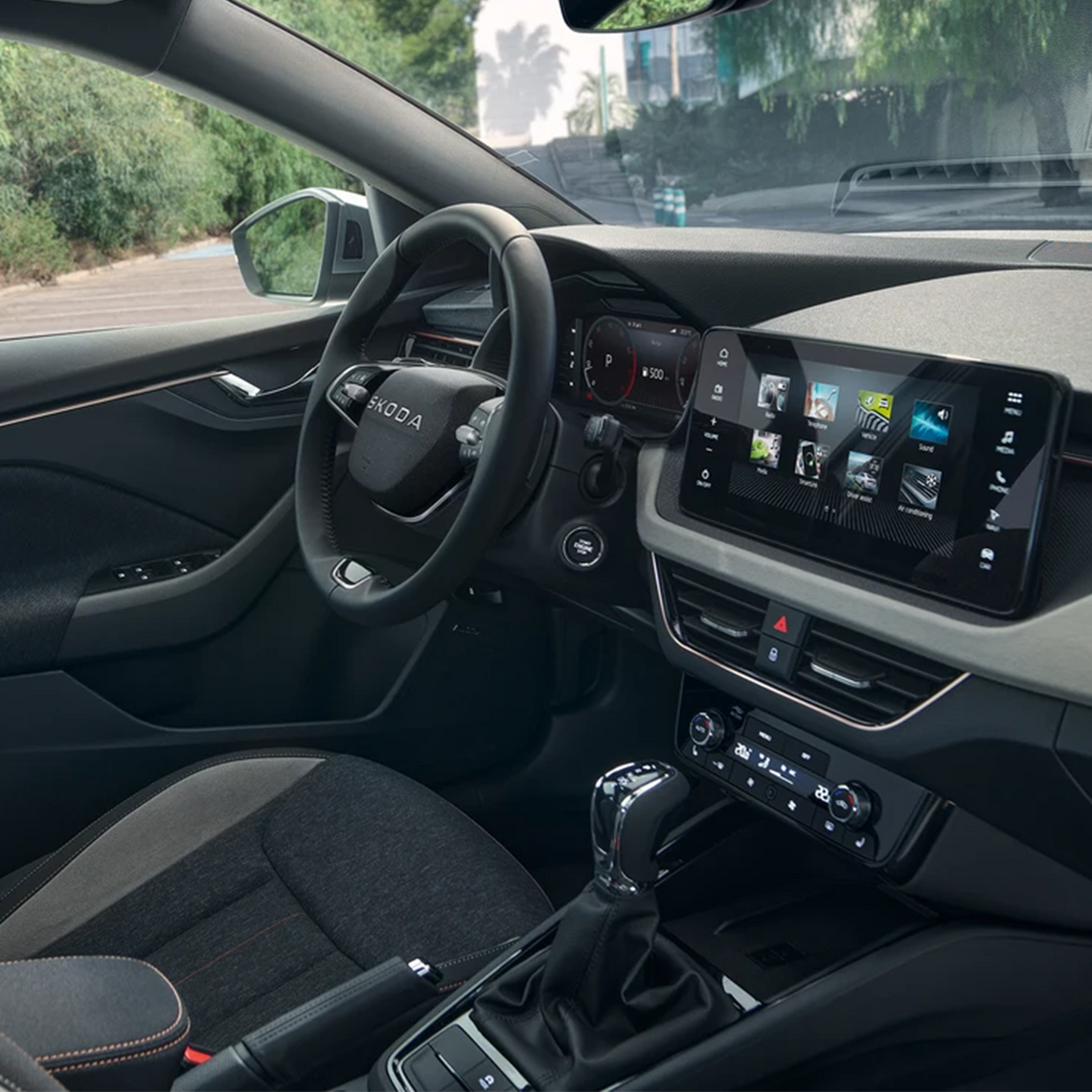 Innenraum eines Škoda-Fahrzeugs mit Fokus auf das Cockpit: gut sichtbares Multifunktionslenkrad, Schalthebel und mittig ein großes Touchdisplay