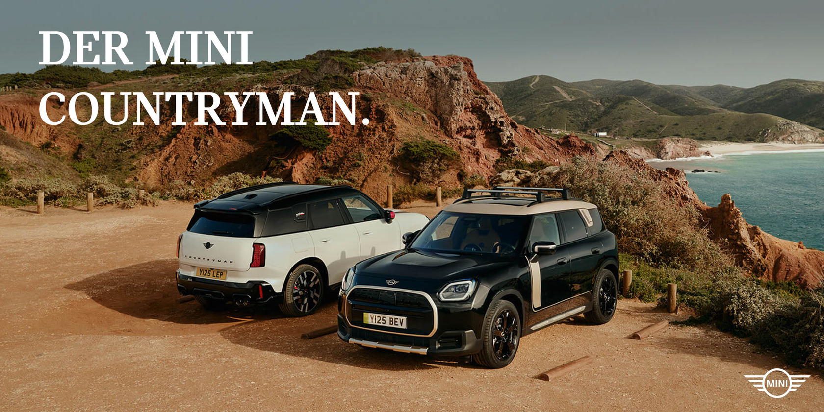 Headergrafik ‚Der MINI Countryman‘ mit zwei MINI Countryman Modellen an einer Küstenlandschaft: ein schwarzer und ein weißer Countryman stehen auf einem Aussichtspunkt mit Meerblick.
