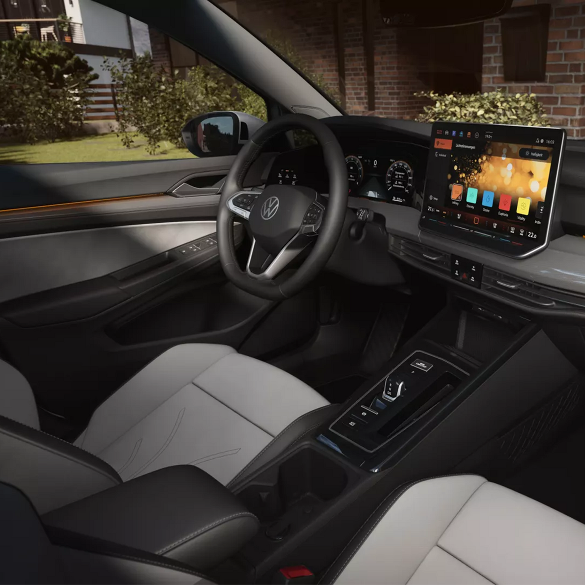 Modernes Cockpit eines Volkswagen Golf Variant (Facelift 2024) mit großem Touchscreen-Infotainmentsystem, Multifunktionslenkrad und eleganter Zweifarben-Lederausstattung in hellgrau und schwarz.